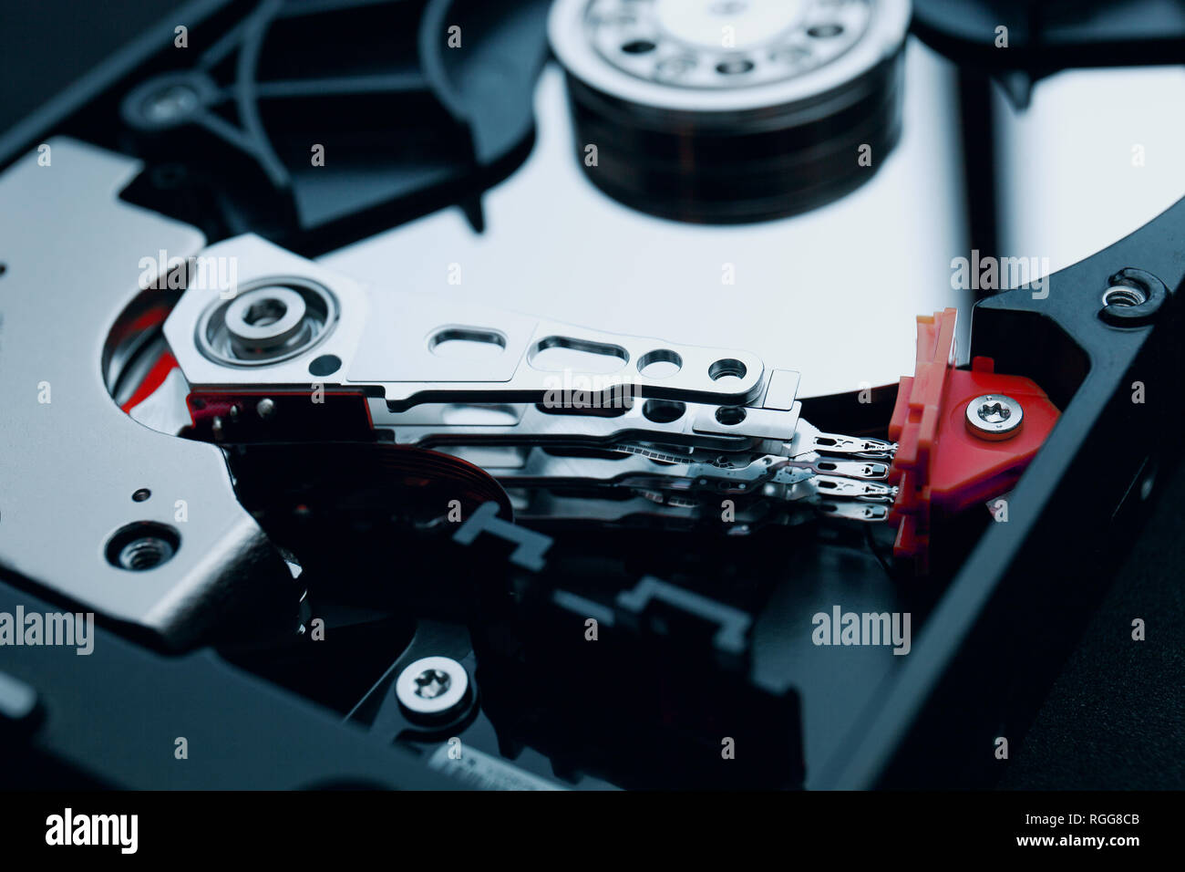 Disassembled magnetic device hard disk, hard drive, data storage, HDD, Read and write head with the shiny metal platter. IT Technology, Computer perip Stock Photo