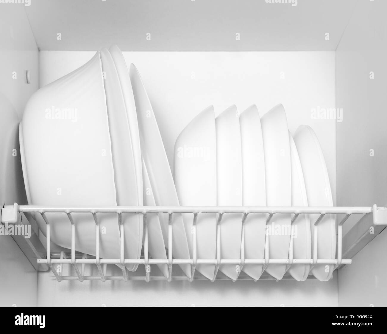 Clean dishes drying on metal dish rack on shelf Stock Photo - Alamy