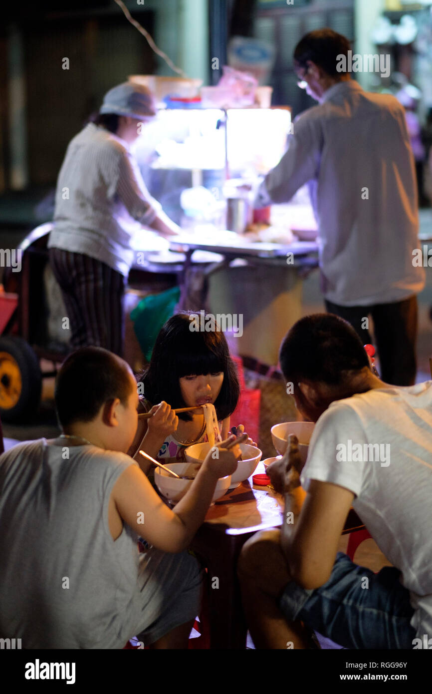 Kids eating street food in Hoi An, Vietnam, Southeast Asia Stock Photo