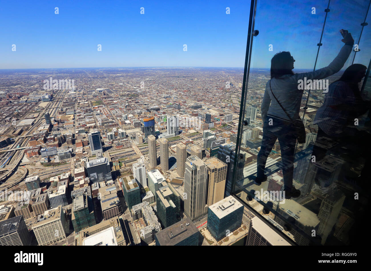 Tourists taking selfie on "The Ledge" of the Skydeck observation deck on top of the Willis Tower (former Sears Tower). Chicago, Illinois, USA Stock Photo