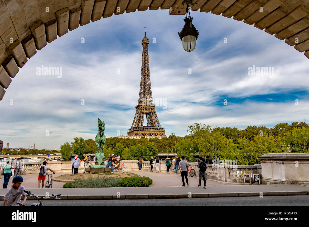 Looking through the archway of Bir-Hakeim Bridge at people on one of the outlooks admiring the spectacular  view of the Eiffel Tower,Paris Stock Photo