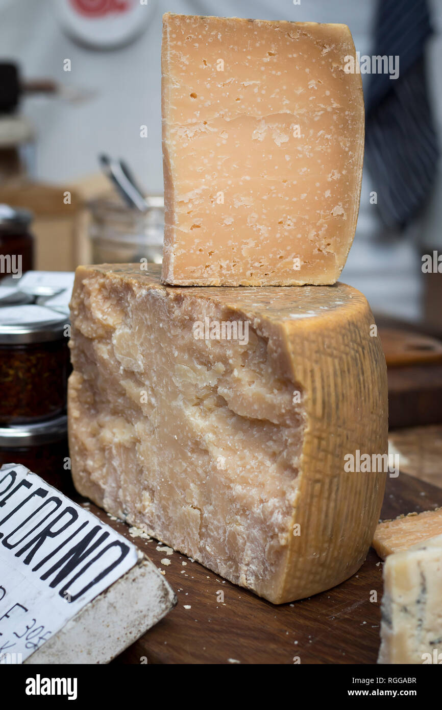 Parmesan is on the table for sale on the market. ParmigianoReggiano is