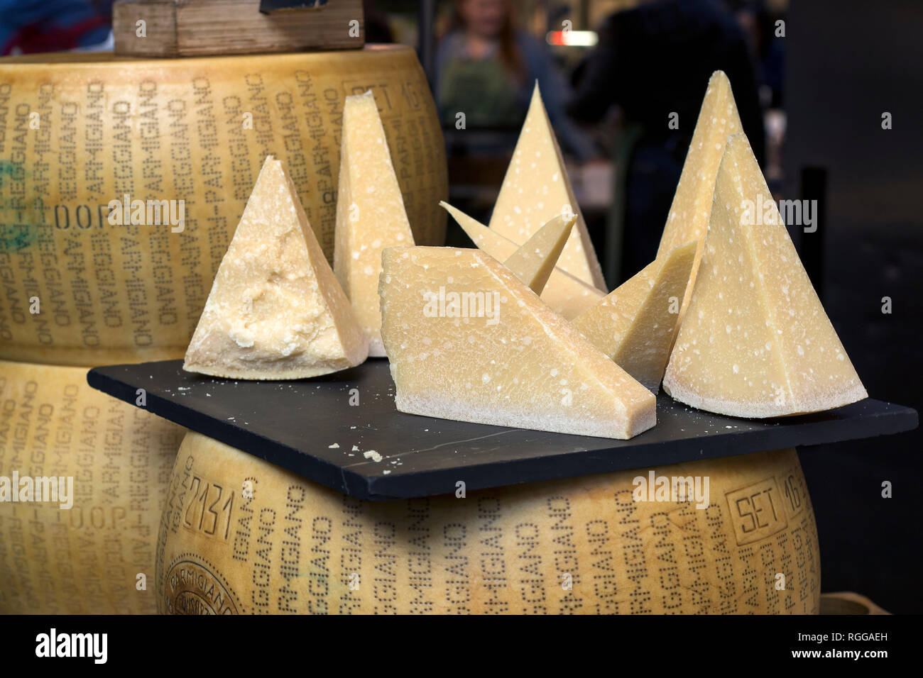 Parmesan is on the table for sale on the market. ParmigianoReggiano is