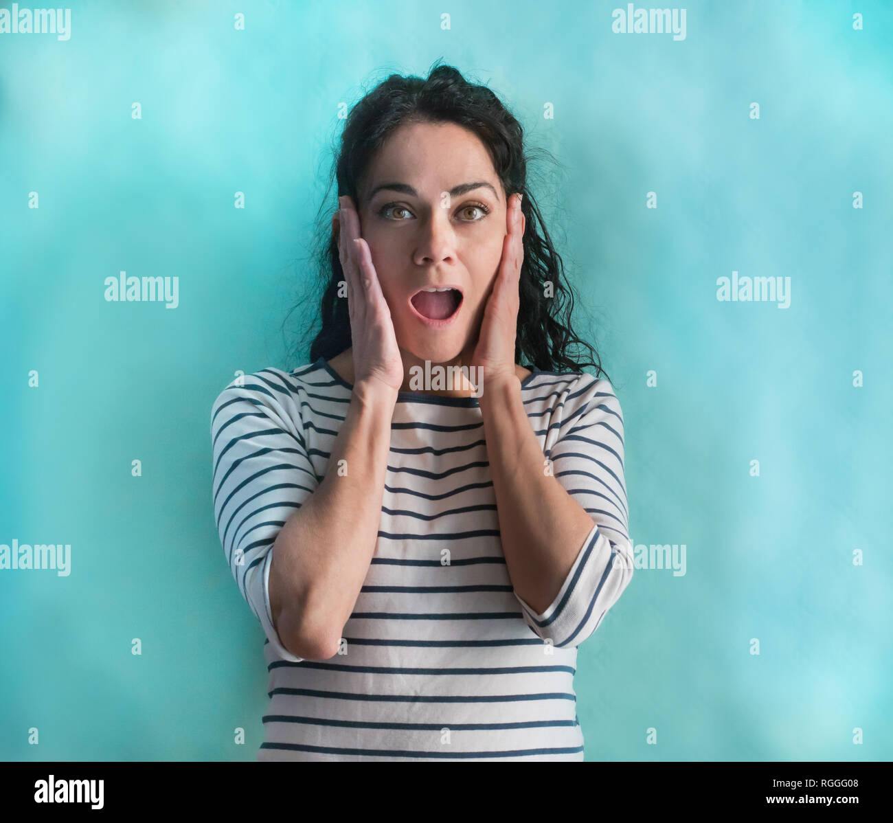 Beautiful hispanic woman wearing stripes sweater celebrating crazy and amazed for success with arms raised and open eyes screaming excited. Winner con Stock Photo
