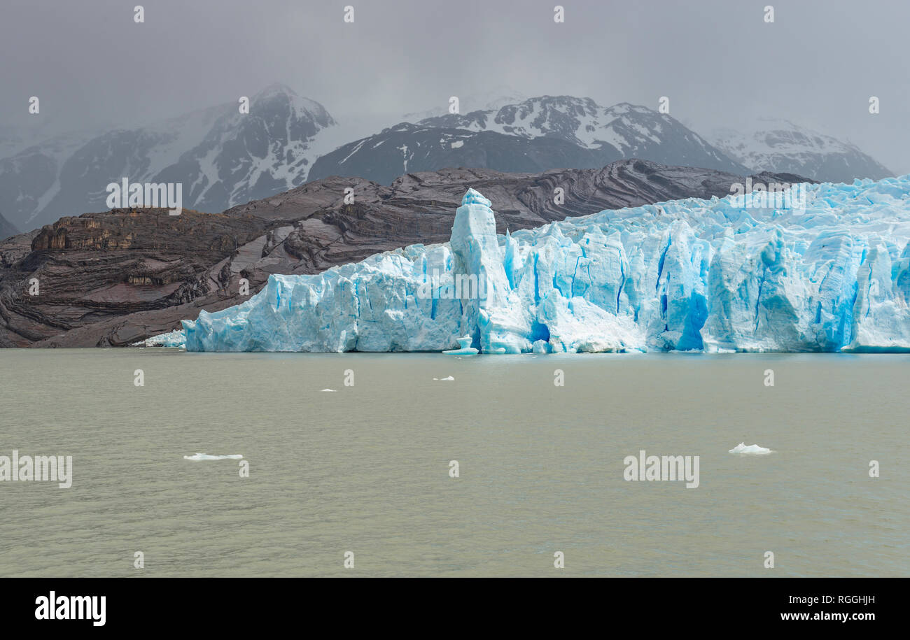 The giant Grey Glacier and the Andes mountain range in the mist on a Grey Lake navigation, Torres del Paine national park, Puerto Natales, Chile. Stock Photo