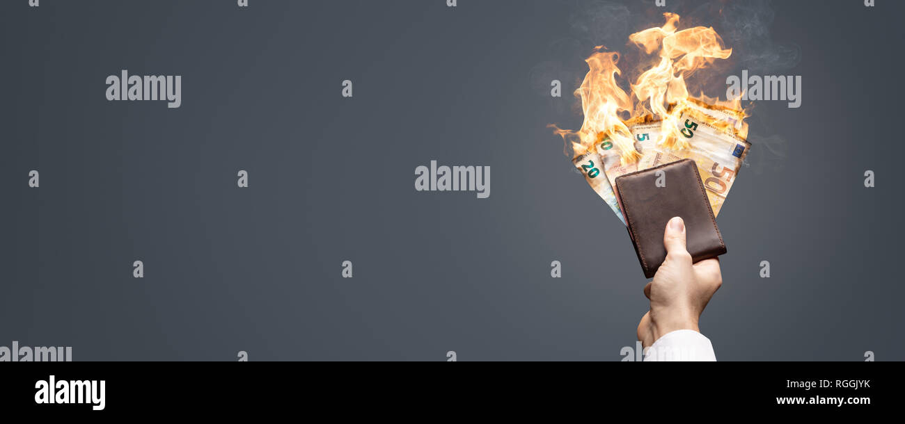 Burning Euro bills in a hand-held wallet Stock Photo