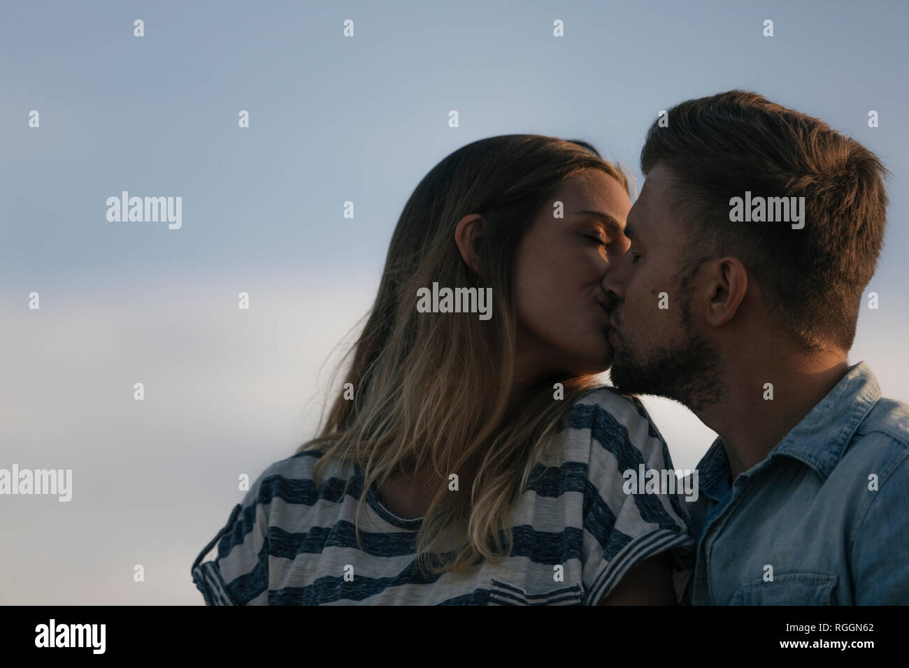 Young couple kissing outdoors Stock Photo