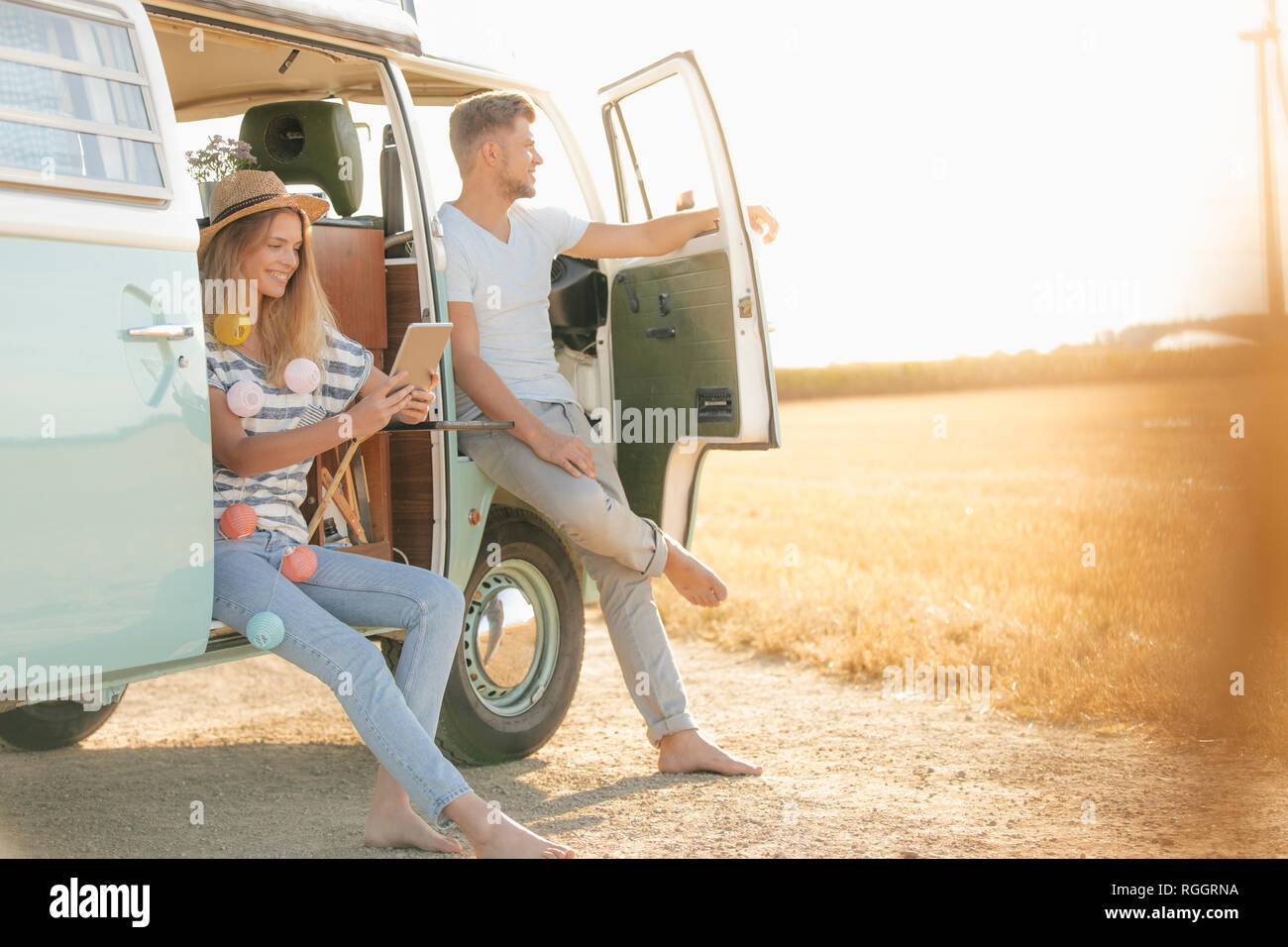 Young couple relaxing at camper van in rural landscape Stock Photo - Alamy