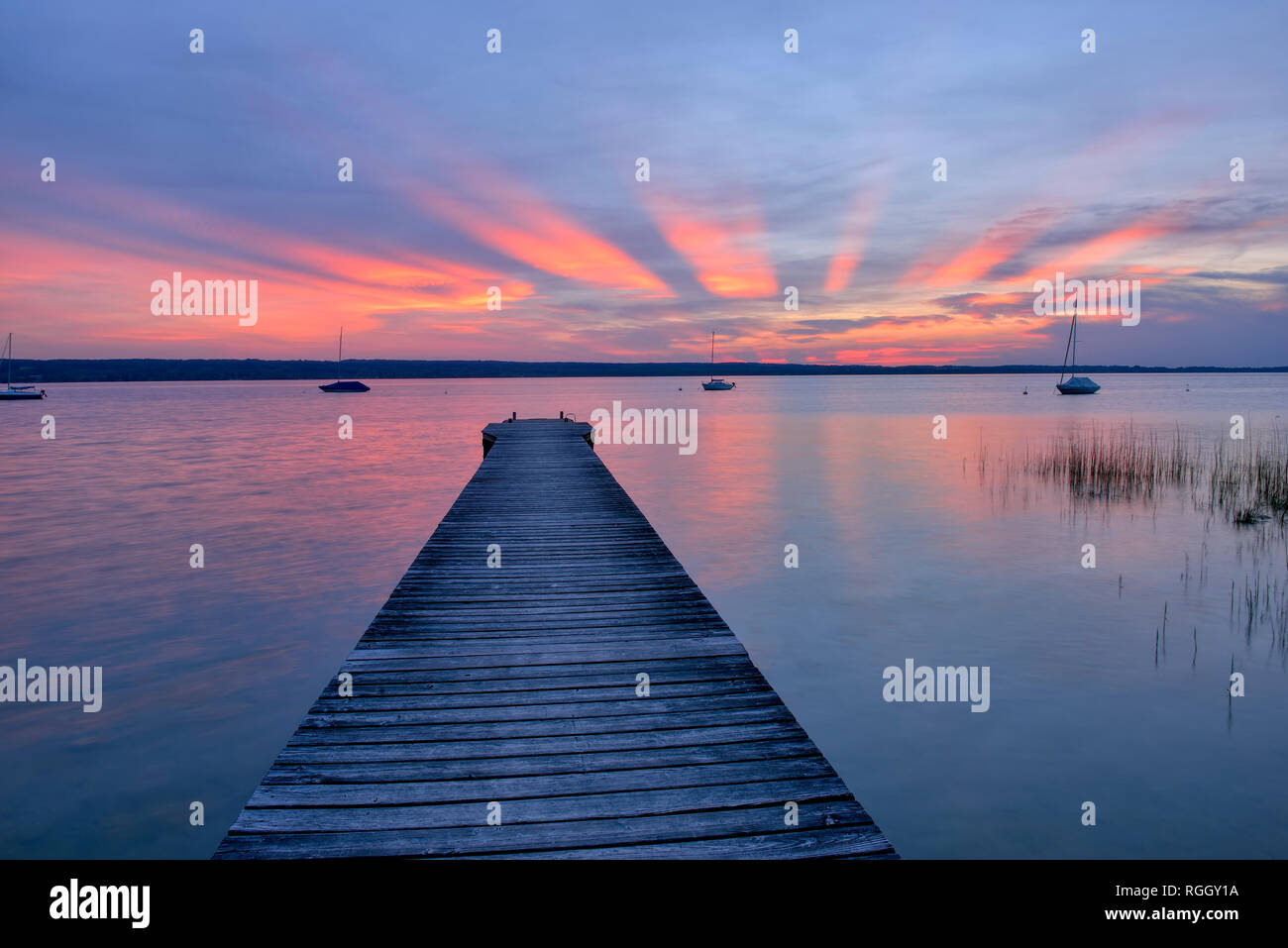 Wooden jetty at sunset at Lake Ammersee, Fuenfseenland, Bavaria, Germany. Stock Photo