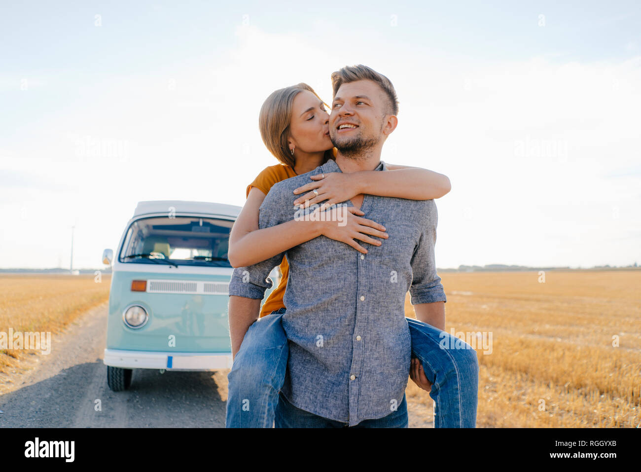 Happy couple at camper van in rural landscape Stock Photo
