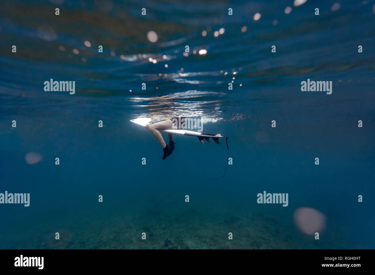 Under water surfer sitting surfboard hires stock photography and