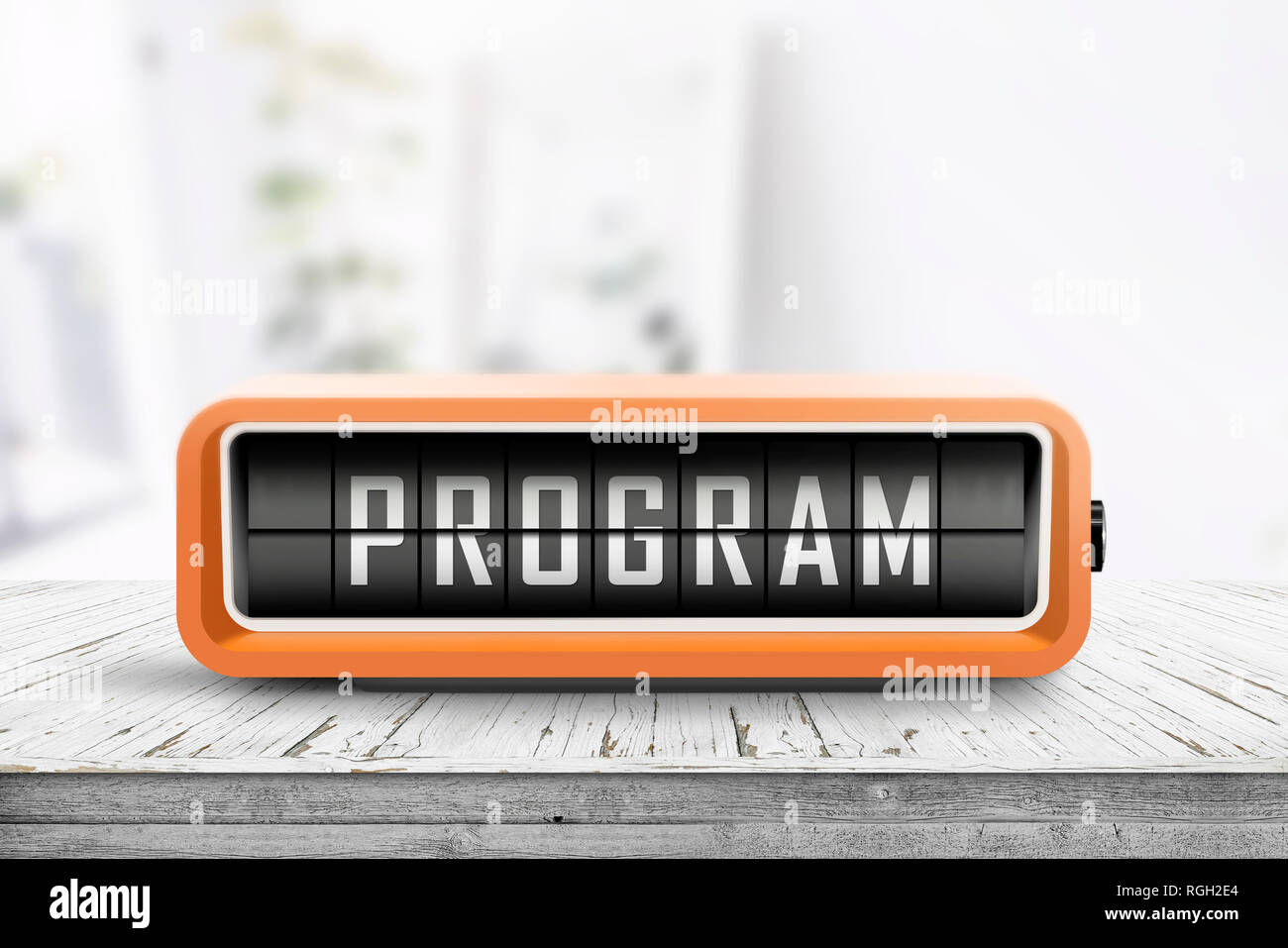 Program message on a retro clock in orange on a wooden table in bright light Stock Photo