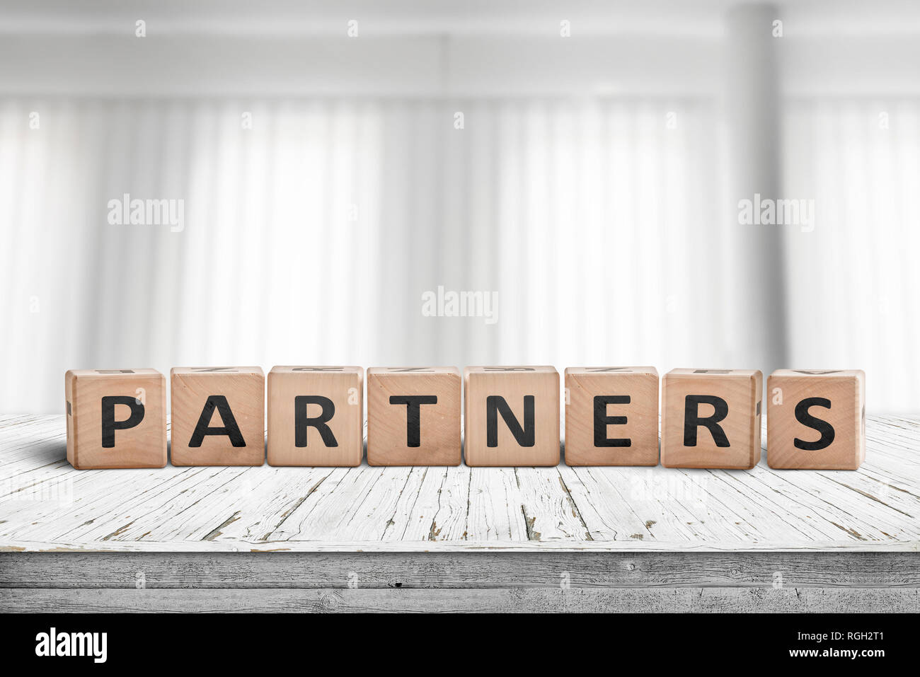 Partners Sign On A Desk In A Bright Office With White Curtains In