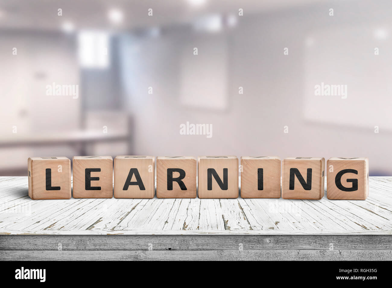 Learning in a classroom with a sign on a wooden table in a bright room Stock Photo
