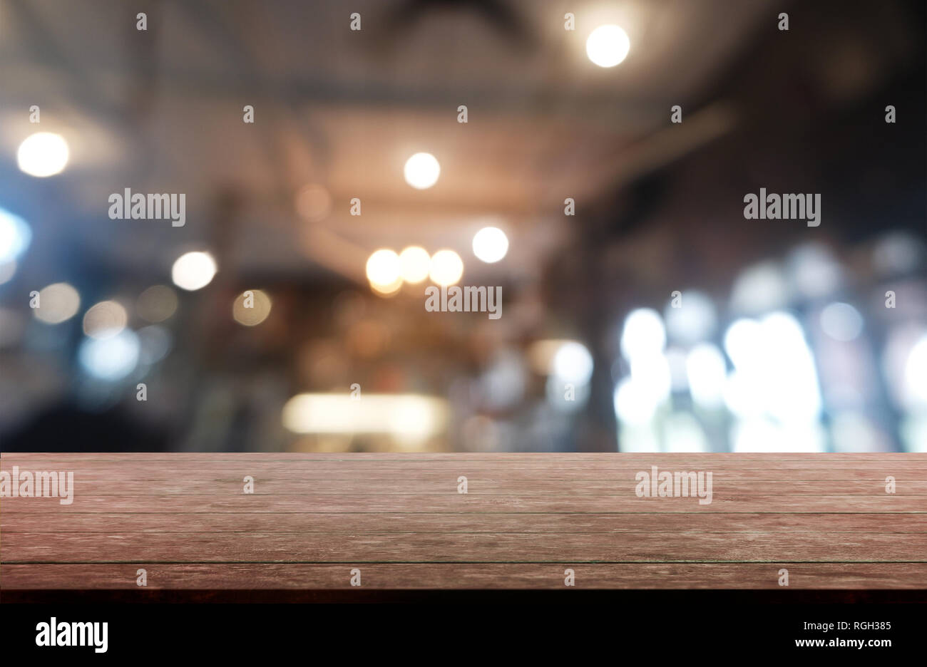 Empty dark wooden table in front of abstract blurred background of restaurant, cafe and coffee shop interior. can be used for display or montage your  Stock Photo