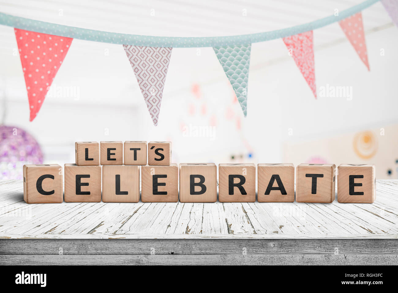 Let's celebrate birthday greeting in a bright kids room with flags hanging from the ceiling Stock Photo