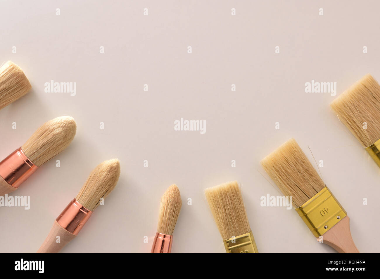 Set of paintbrushes for house painter of various sizes and shapes around on white table. Horizontal composition Stock Photo