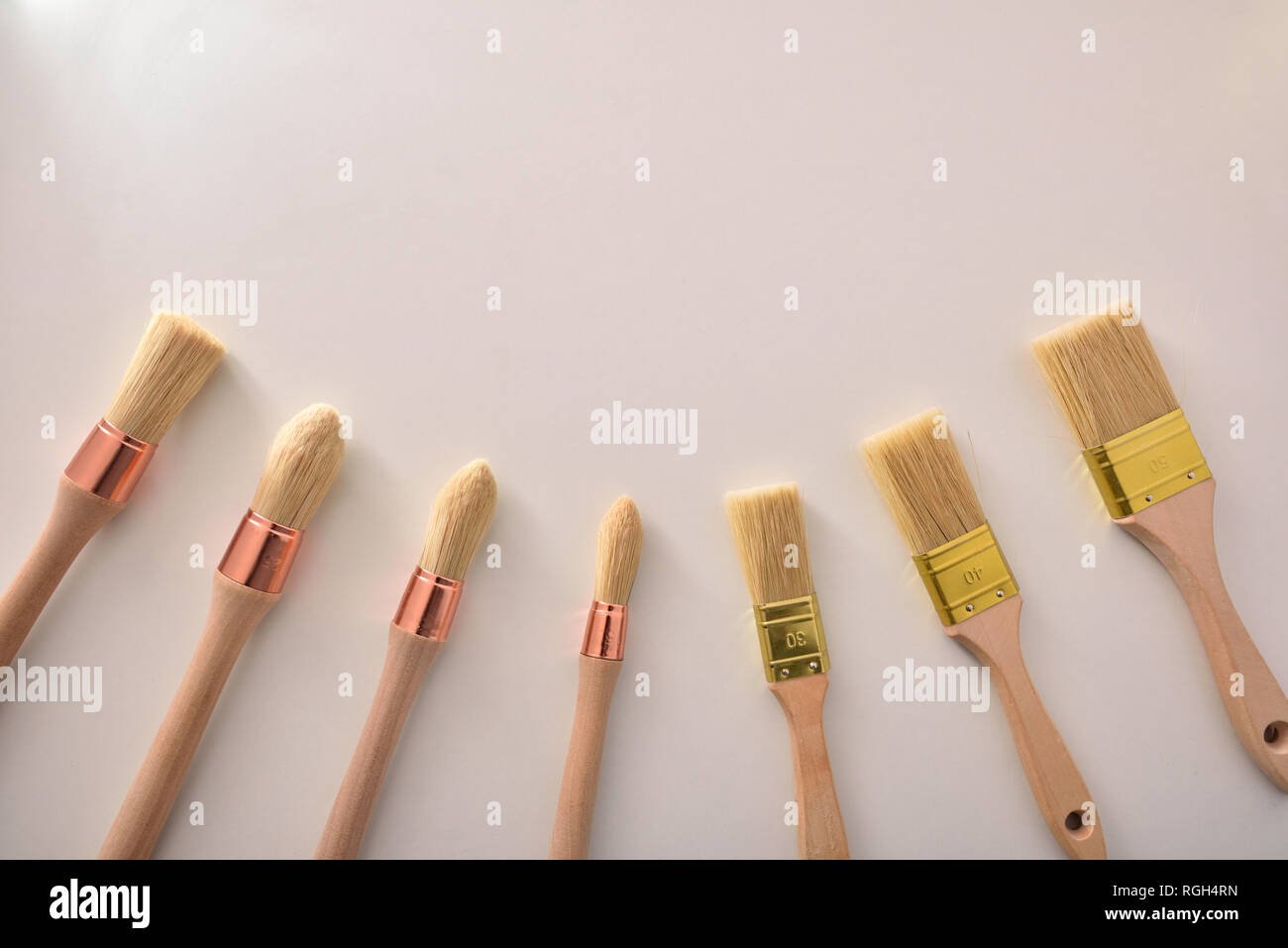 Set of paintbrushes for house painter of various sizes and shapes around on white table. Horizontal composition Stock Photo