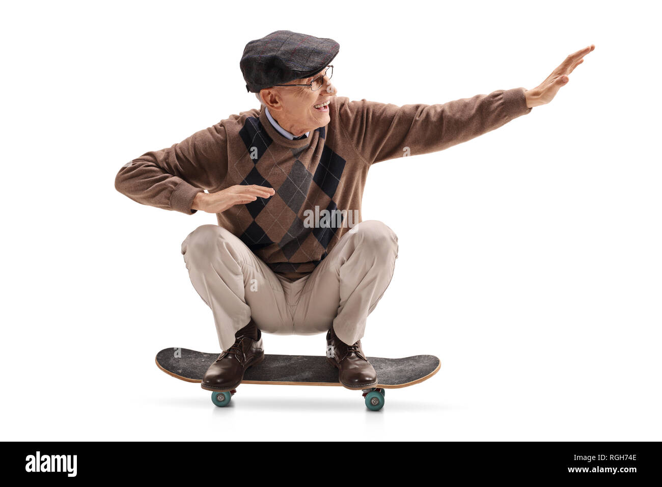 Energetic senior man riding a skateboard isolated on white background Stock Photo