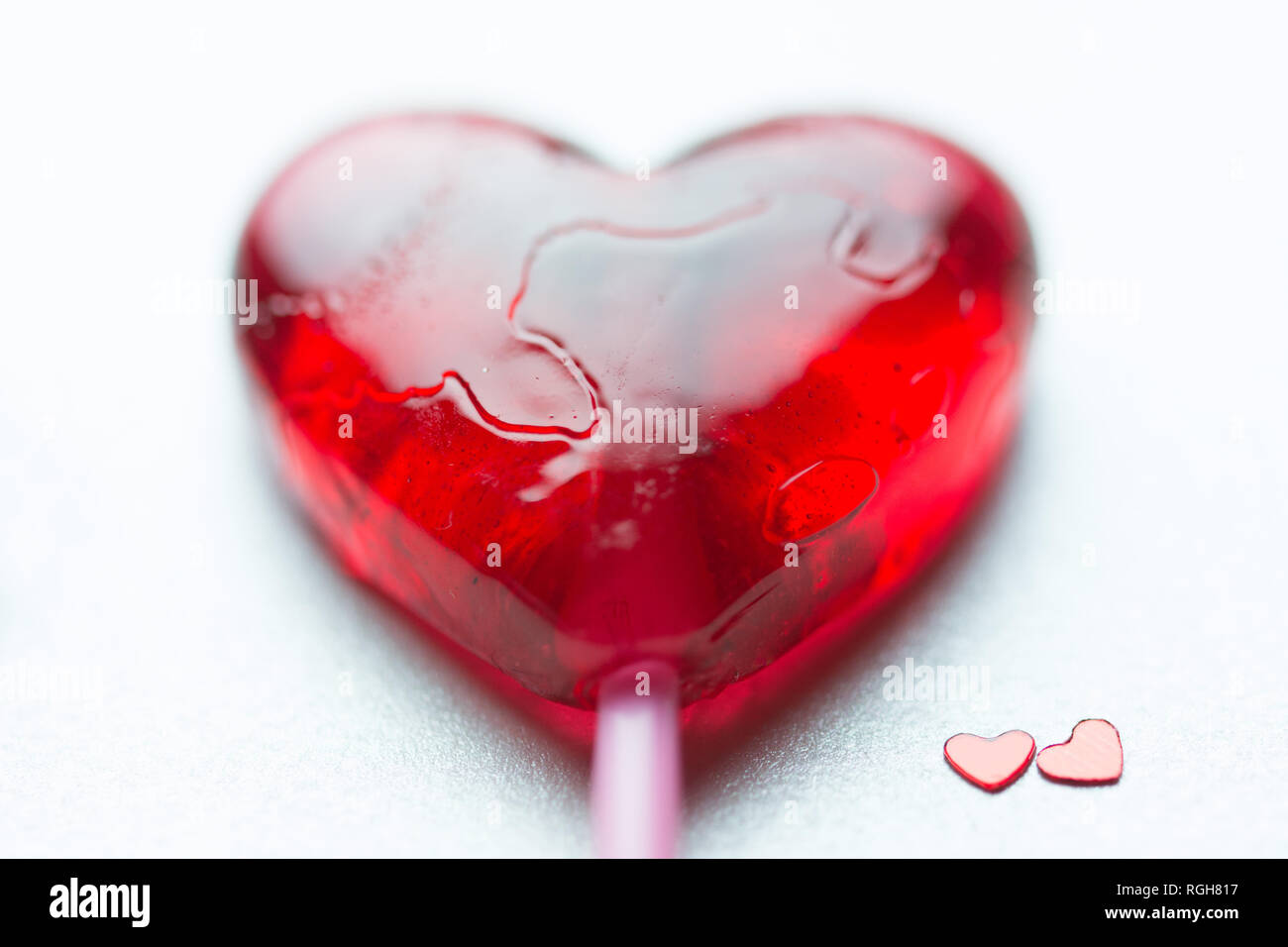 Valentine card with one huge red lollipop heart and two small red hearts at the  bottom right Stock Photo