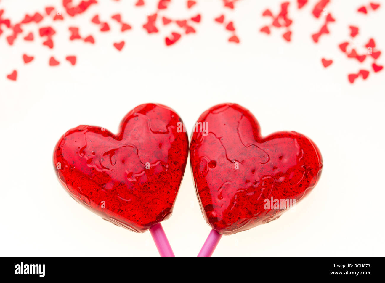 Valentine card with two big red lollipop hearts and many small red hearts at the top, white background Stock Photo