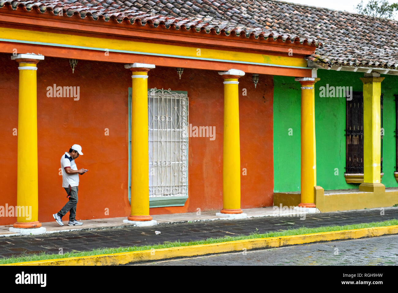A man walks past brightly painted colonnaded style homes in Tlacotalpan