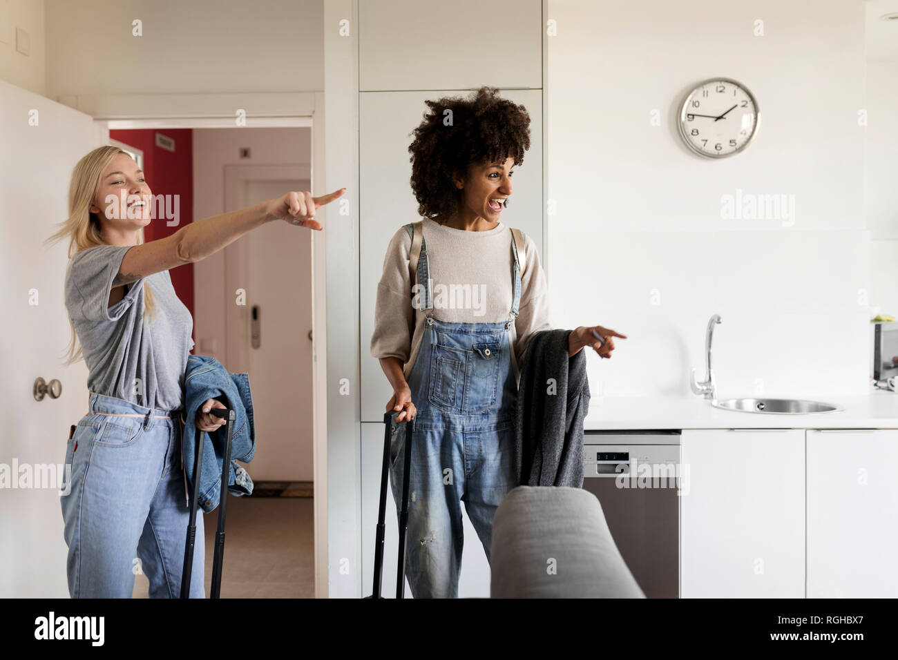 Two excited women with baggage arriving in accomodation Stock Photo