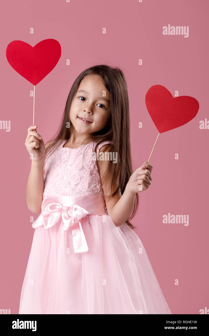 cute little girl in a pink dress holding a paper heart Stock Photo - Alamy