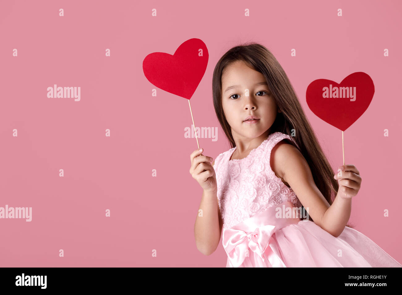 cute little girl in a pink dress holding a paper heart Stock Photo - Alamy