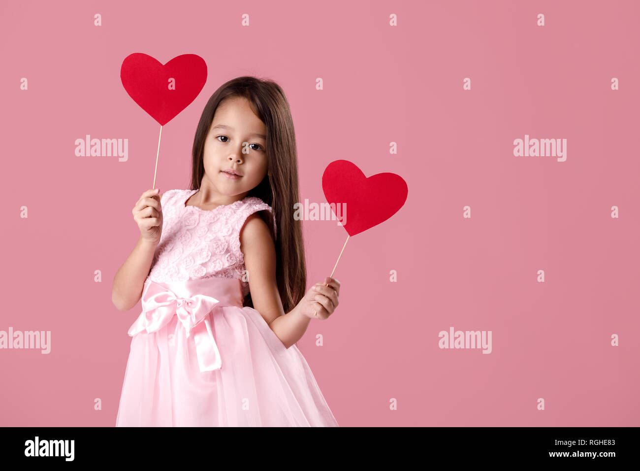 cute little girl in a pink dress holding a paper heart Stock Photo - Alamy