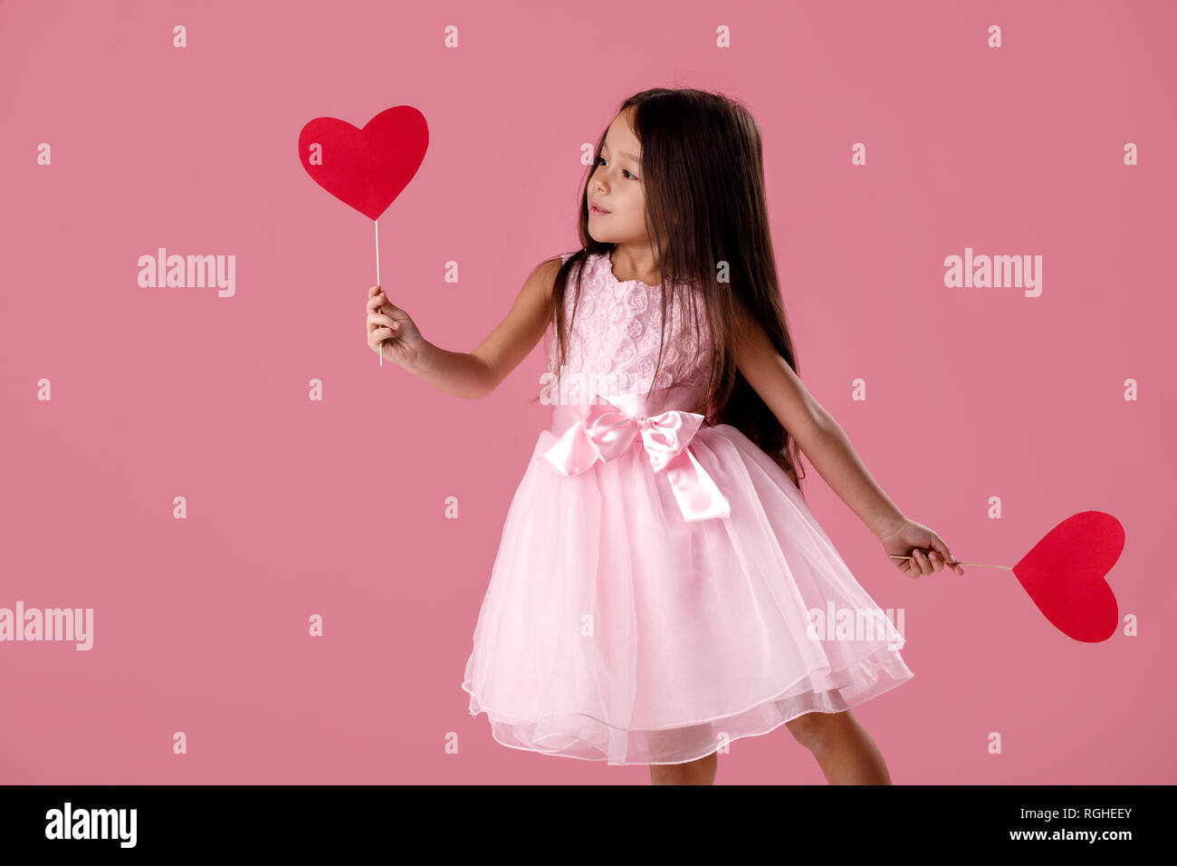 cute little girl in a pink dress holding a paper heart Stock Photo - Alamy