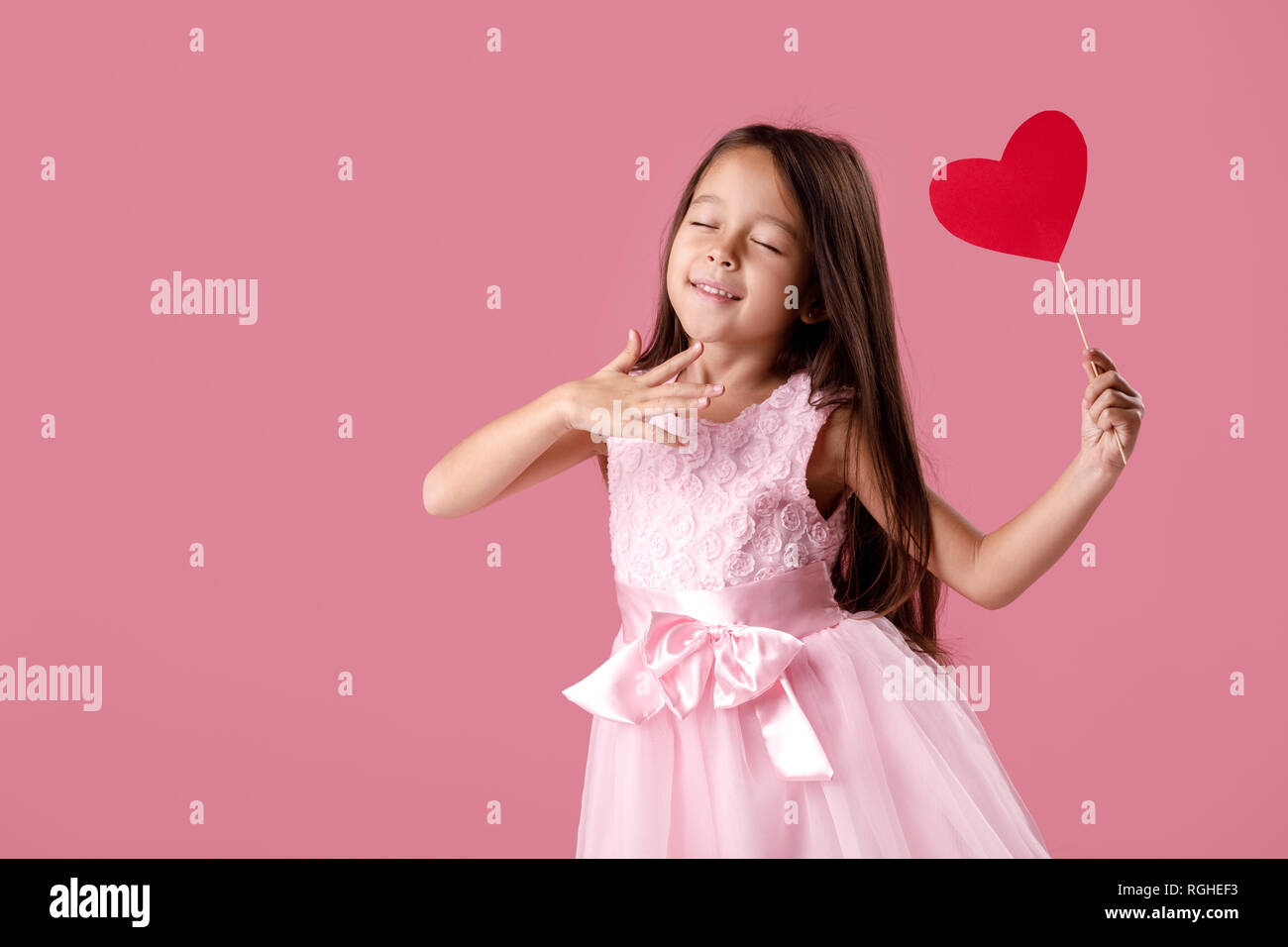 cute little girl in a pink dress holding a paper heart Stock Photo - Alamy