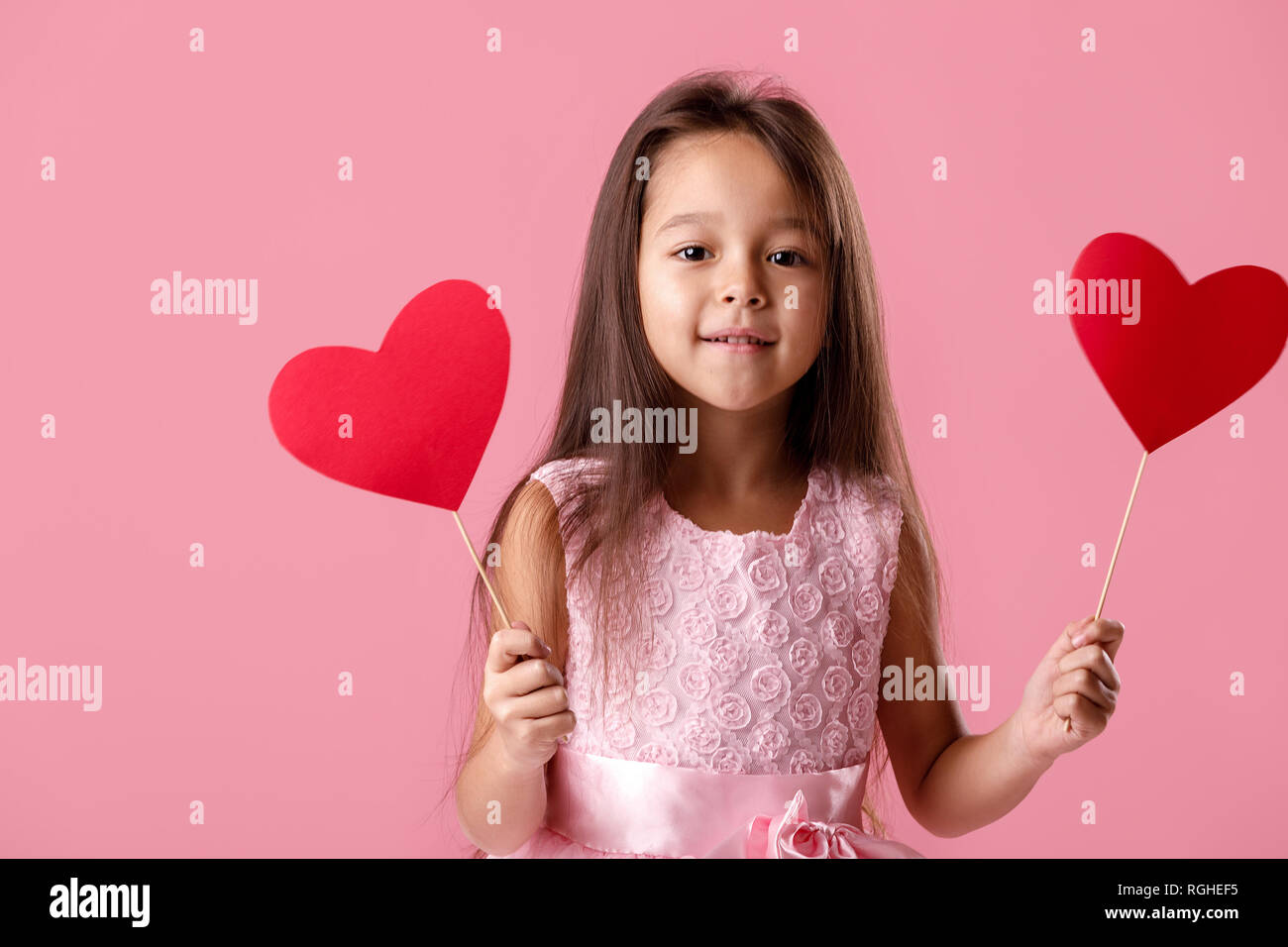 cute little girl in a pink dress holding a paper heart Stock Photo - Alamy