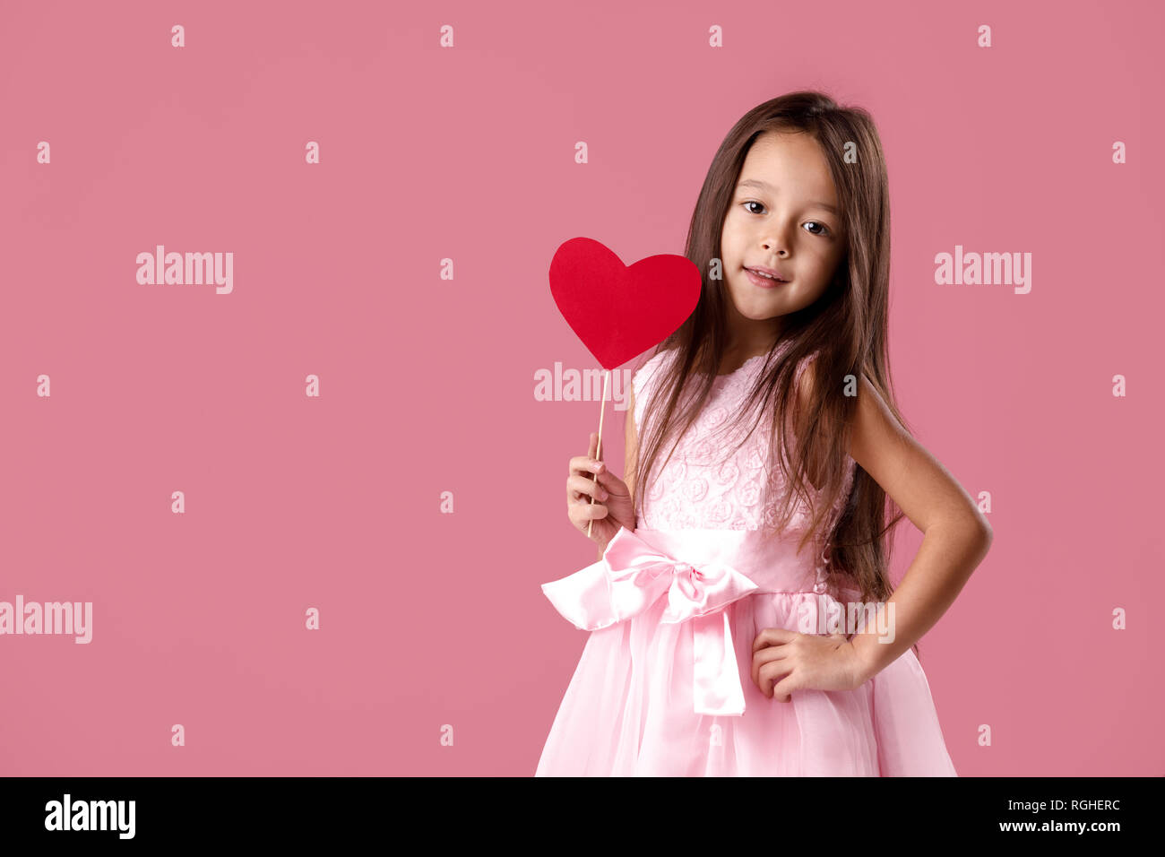 cute little girl in a pink dress holding a paper heart Stock Photo - Alamy