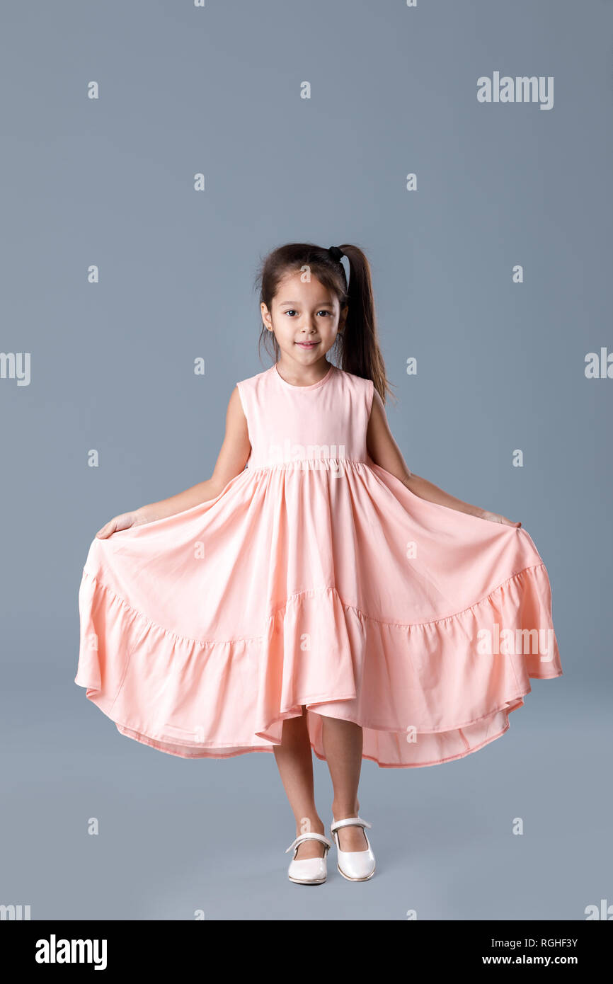 little girl in pink dress posing on gray background Stock Photo - Alamy
