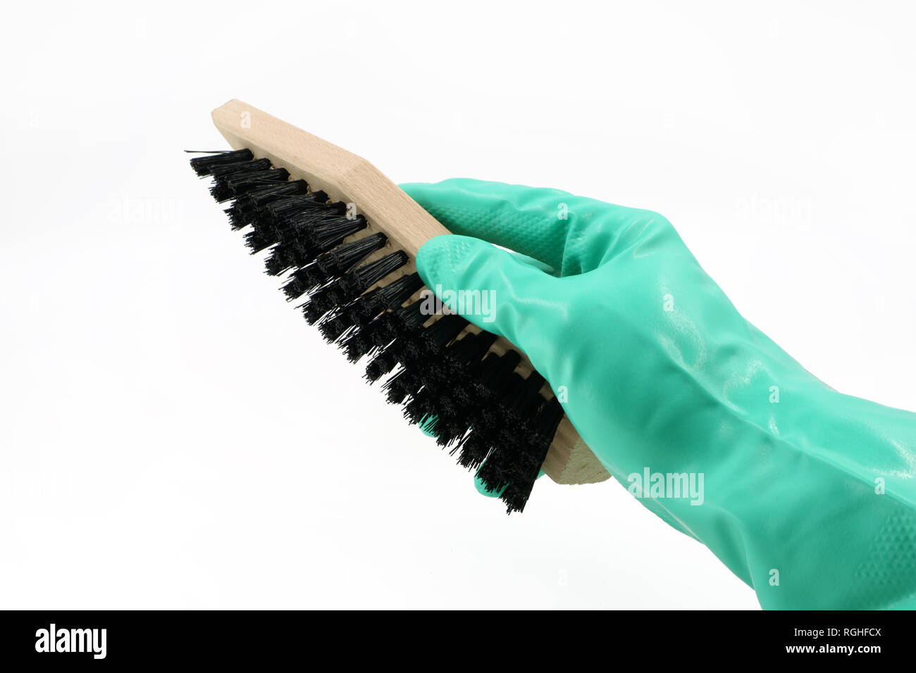 hand with glove is holding a shoe brush isolated on white background Stock Photo
