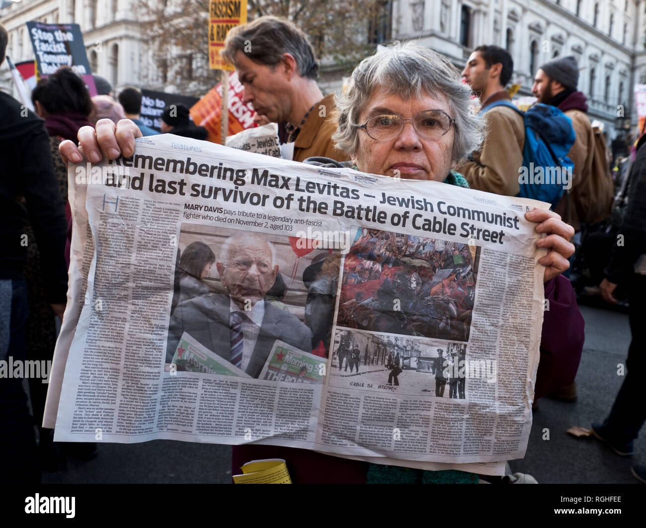 Woman on anti-racism protest holding newspaper remembering Max Levitas, the  Jewish Communist and last survivor of the Battle of Cable Street Stock Photo
