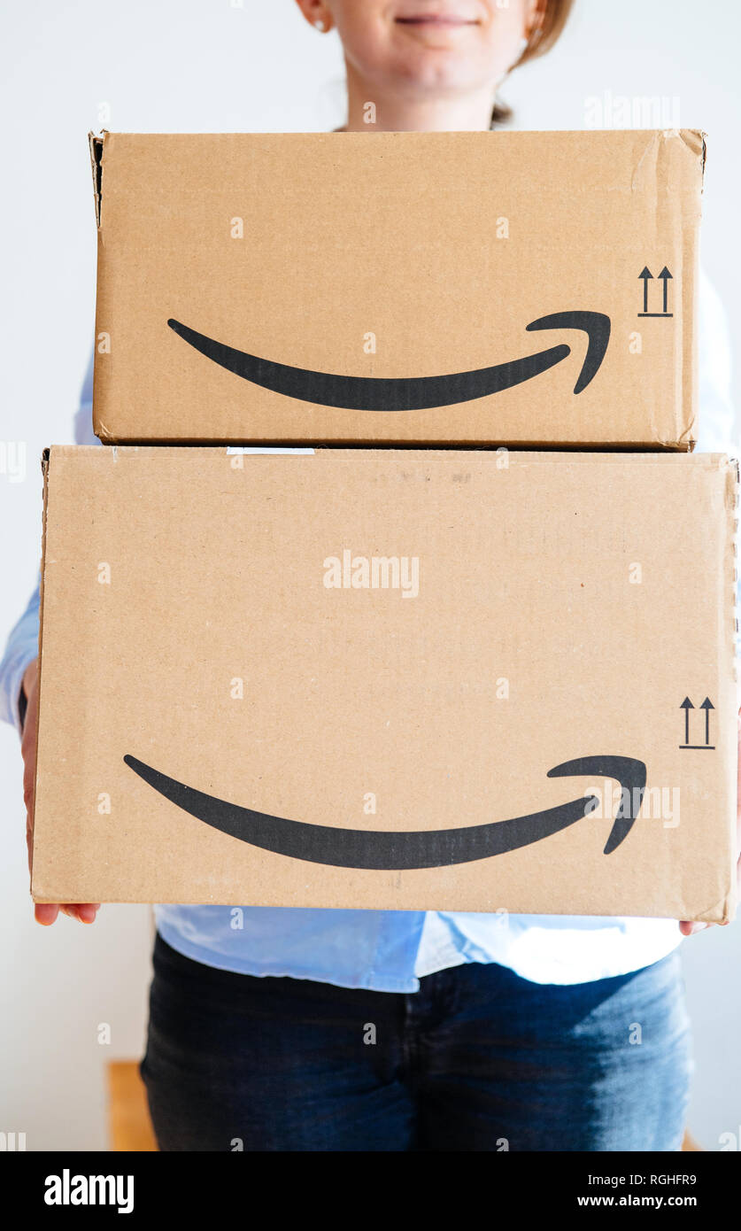 PARIS, FRANCE - MAR 16, 2018: Young happy smiling woman holding two large Amazon Prime cardboard boxing after delivery  Stock Photo