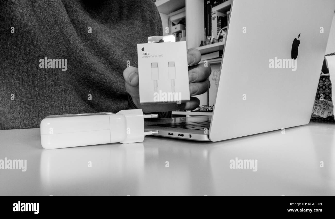 PARIS, FRANCE - FEB 23, 2018: Man unboxing Apple Computers USB-C charging cable bought to power the latest MacBook Pro laptop Stock Photo