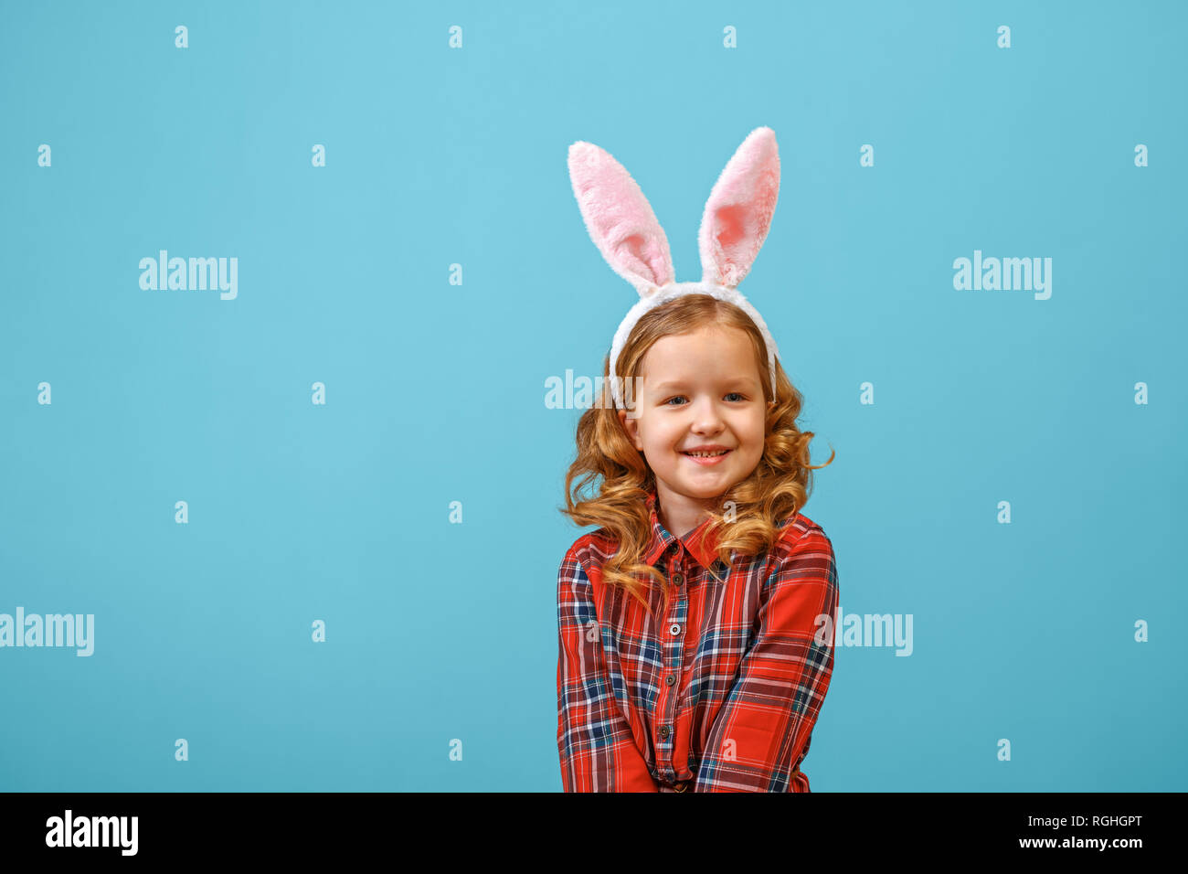 Cute little child girl with bunny ears on a colored background. Happy easter Stock Photo