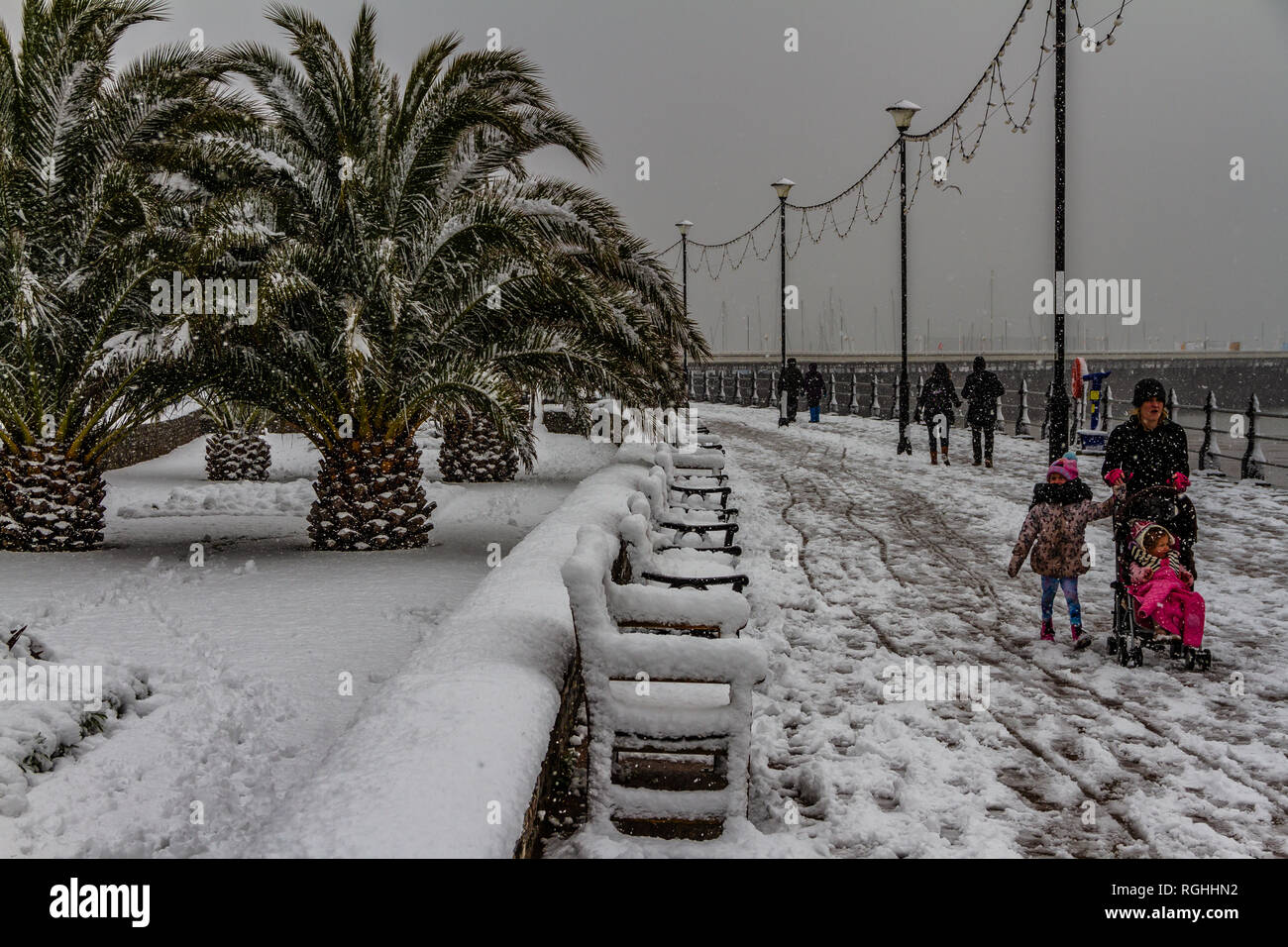 People struggle with the snow and icy conditions while walking along Torquay seafront during the 'Beast from the East' storm in March 2018. Stock Photo