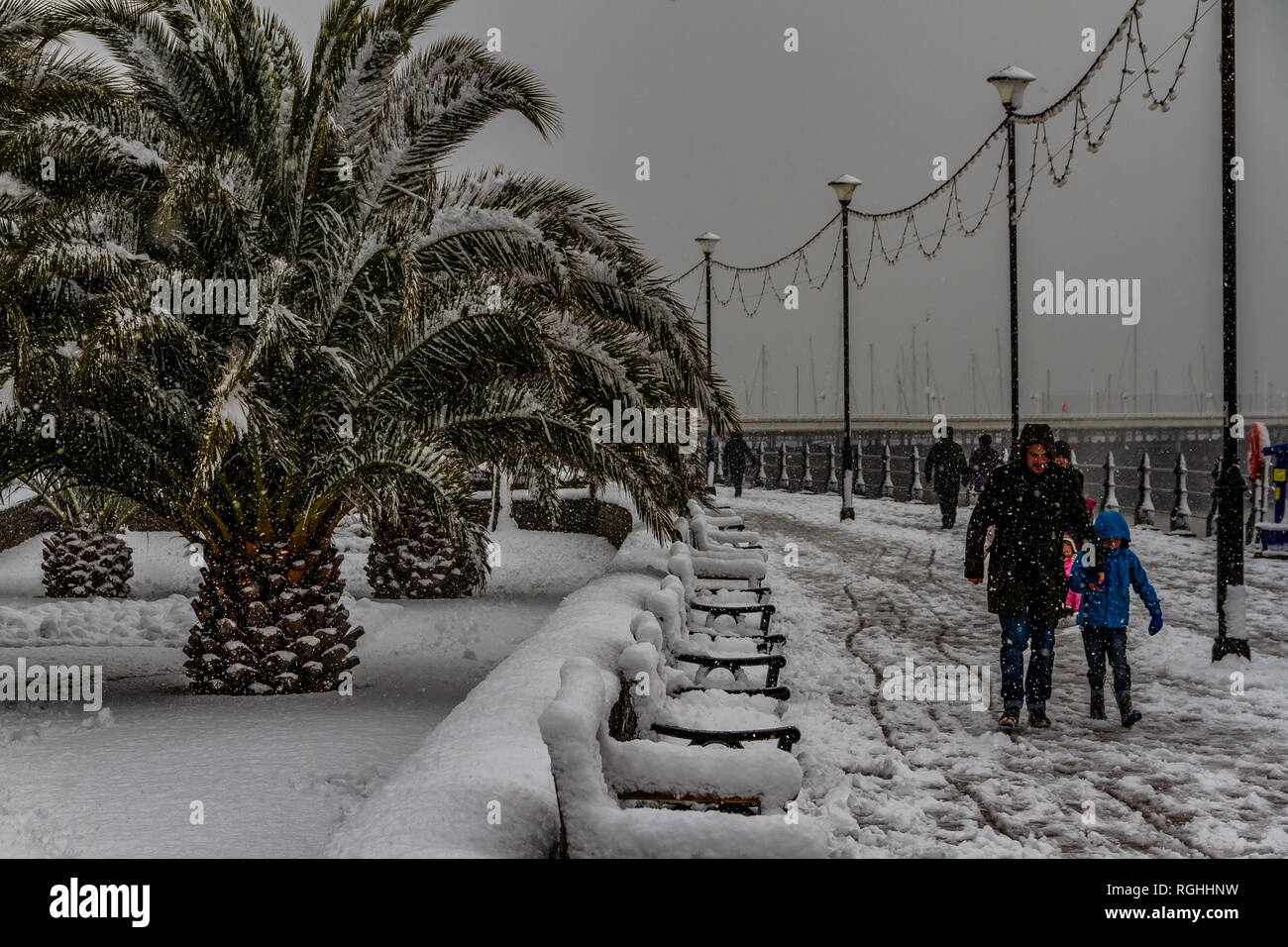 People struggle with the snow and icy conditions while walking along Torquay seafront during the 'Beast from the East' storm in March 2018. Stock Photo