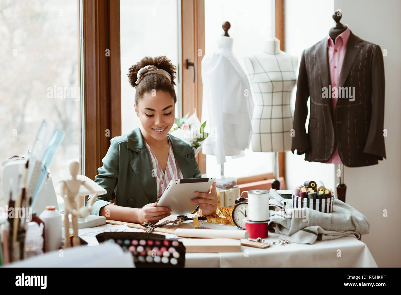 Modeling new design on tablet. Young woman tailor with digital tablet