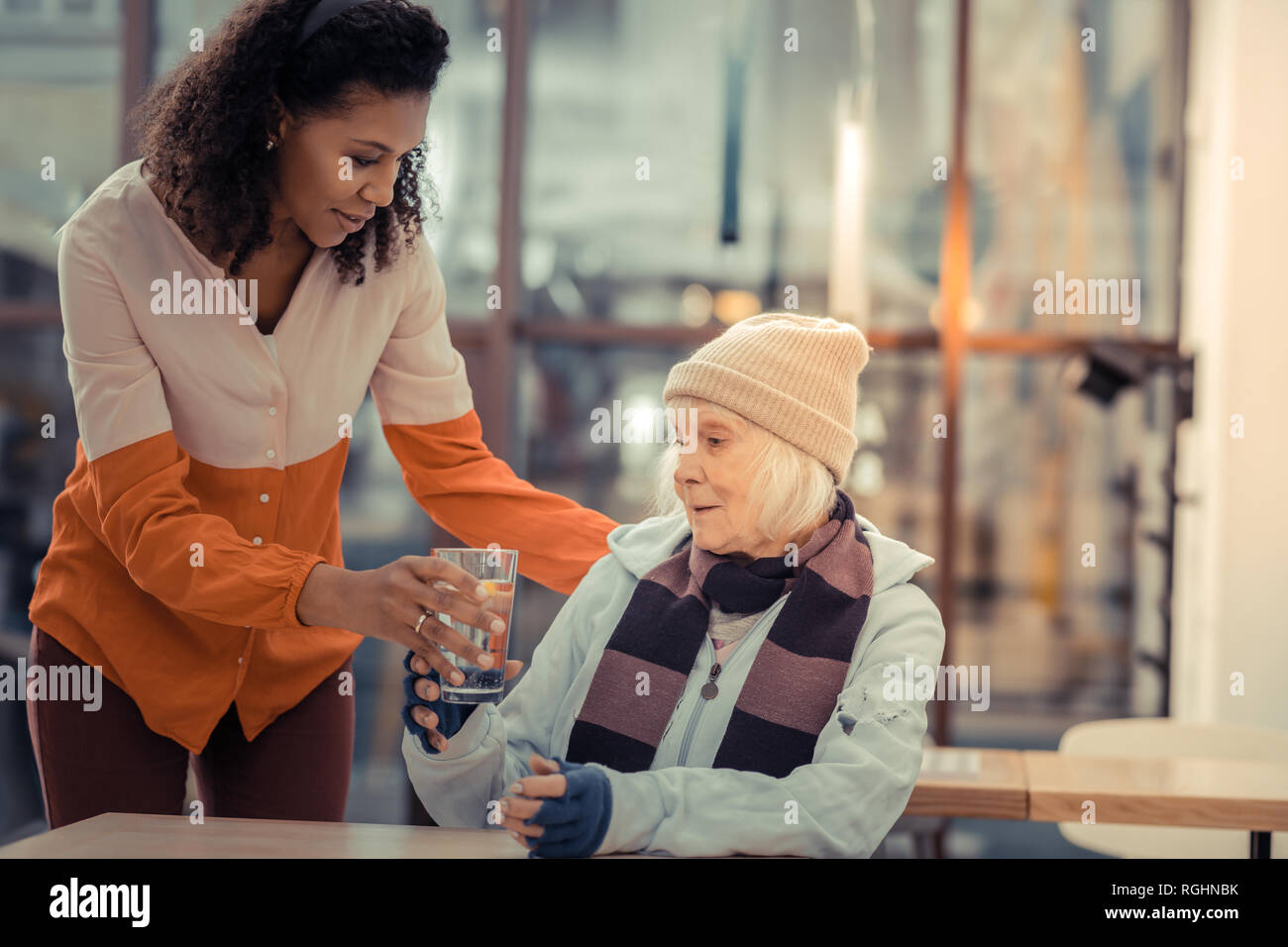 Nice elderly woman taking a glass with water Stock Photo