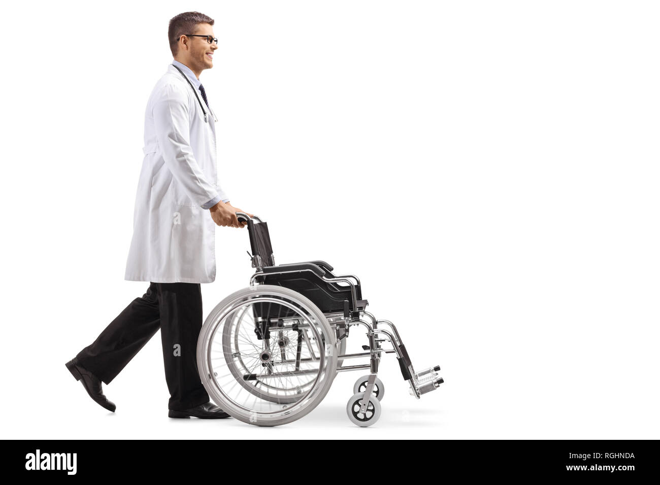 Full length shot of a young male doctor pushing an empty wheelchair isolated on white background Stock Photo