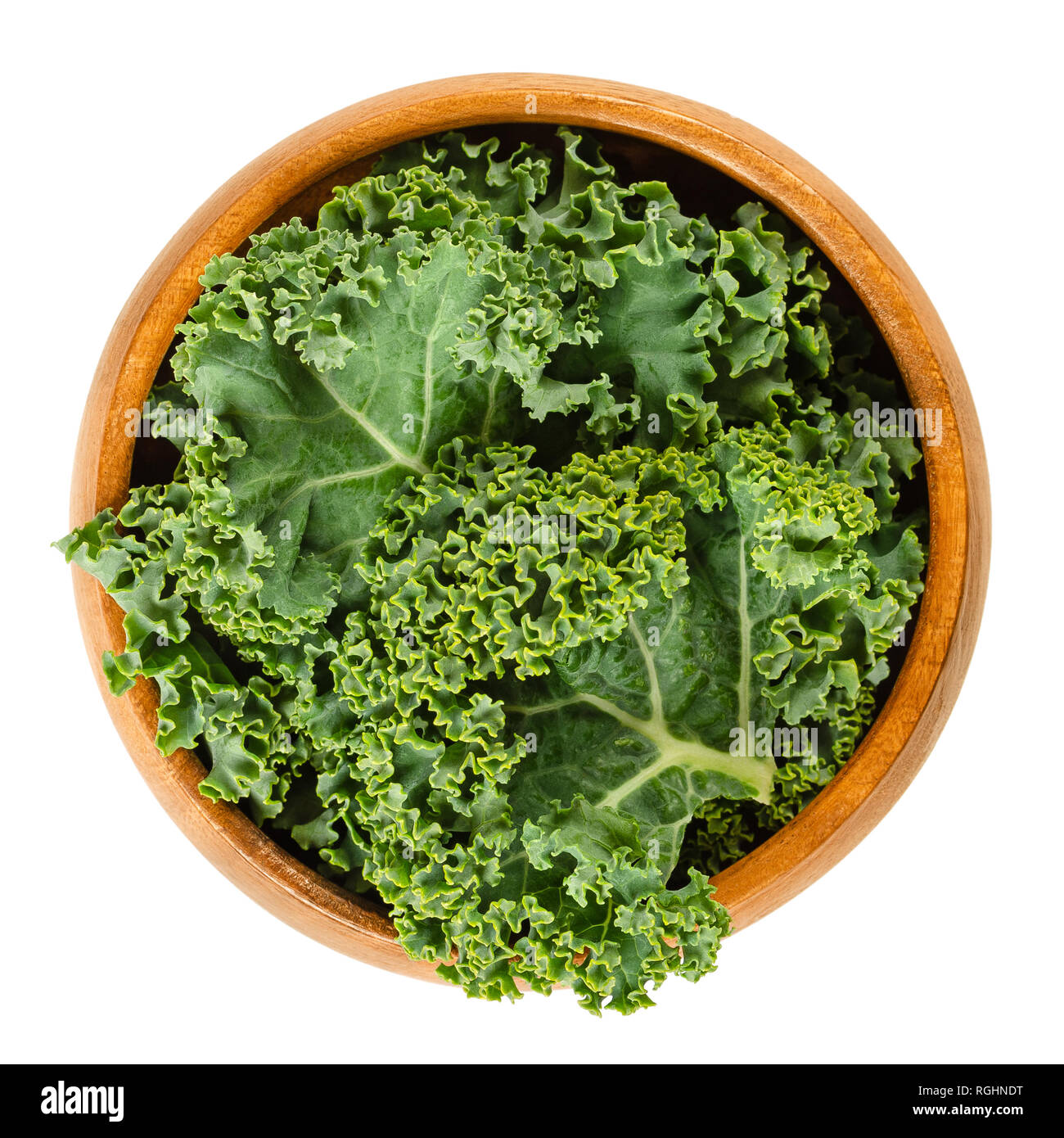 Fresh curly kale leaves in wooden bowl. Also called Scots kale, a leaf cabbage, Brassica oleracea. Edible green and healthy vegetable. Stock Photo