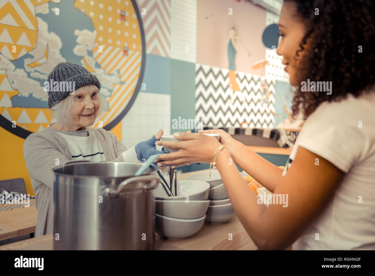 Positive senior woman taking her hot soup Stock Photo