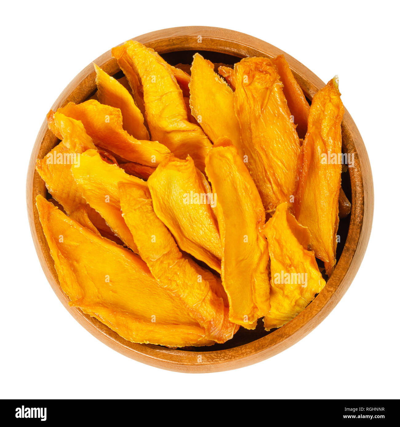 Dried mango strips in wooden bowl. Sliced, dehydrated mangoes. Juicy tropical stone fruit with yellow and orange color. Mangifera. Stock Photo