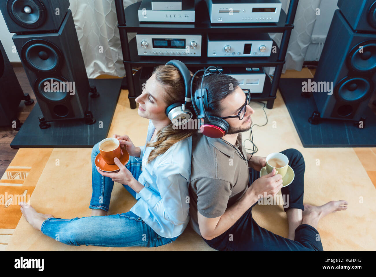 Couple with headphones enjoying music from the Hi-Fi stereo Stock Photo