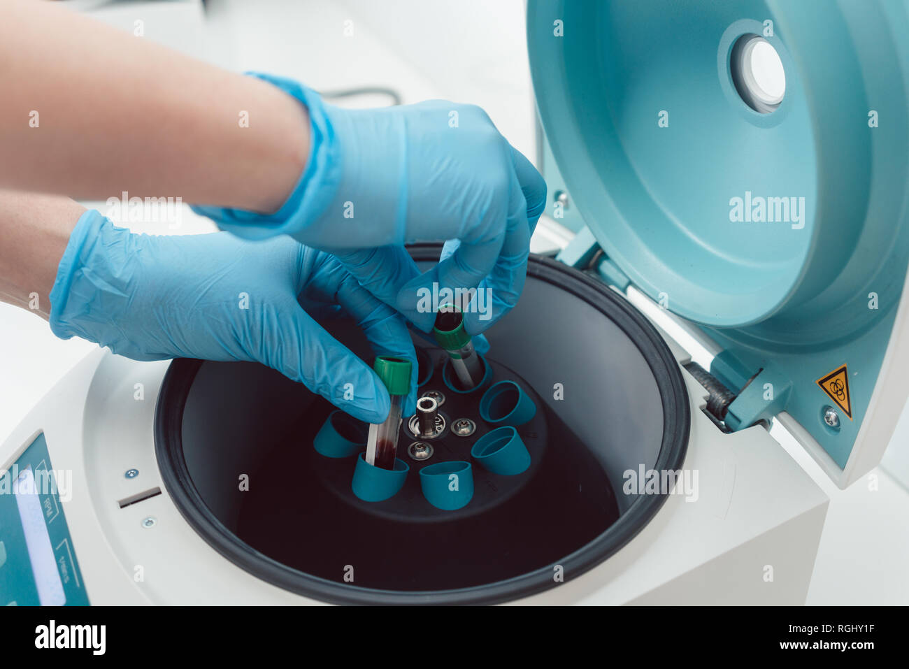 Doctor or lab technician putting blood samples in centrifuge Stock Photo